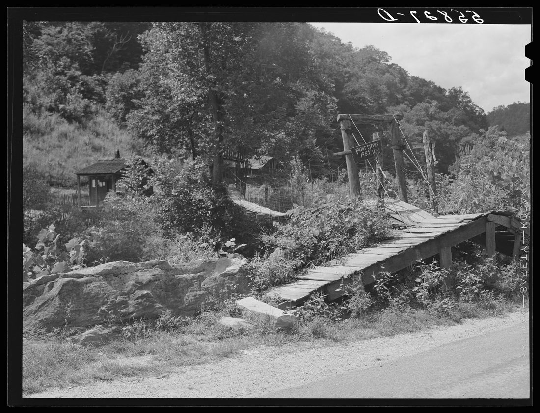 Swinging bridge crossing over creek from main road to post office and store. Ary, Kentucky