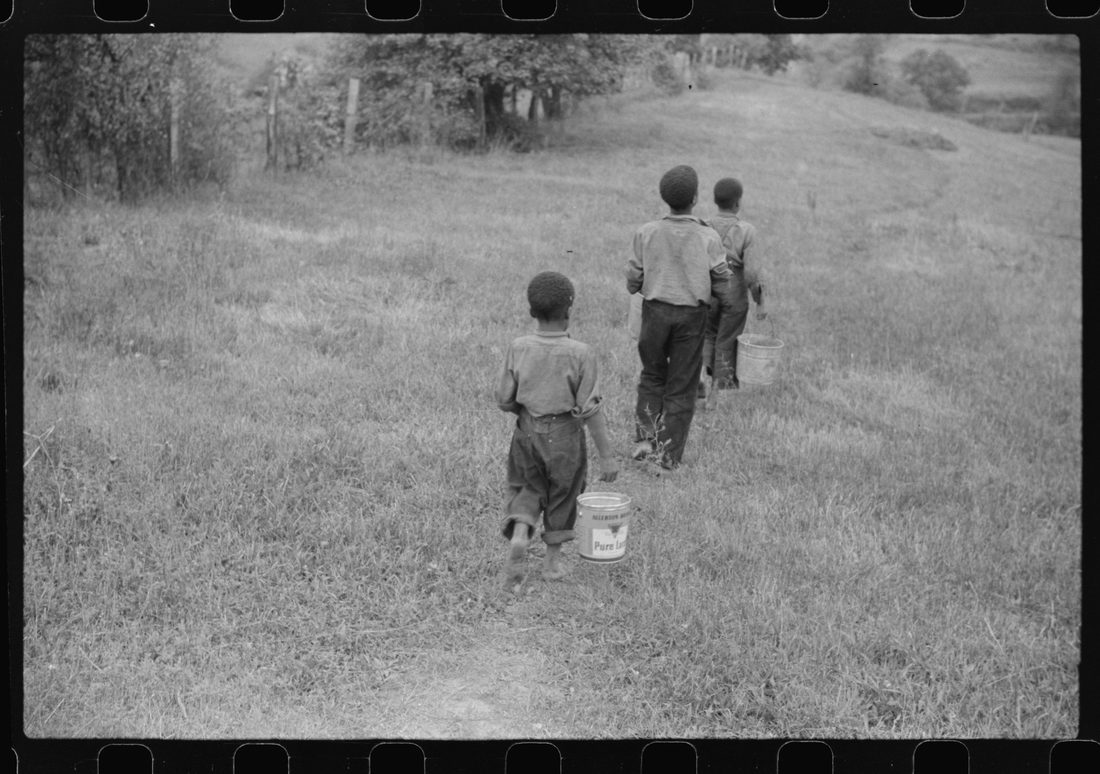 Three of miner's children going down hill to get water in old lard cans. Chaplin, West Virginia
