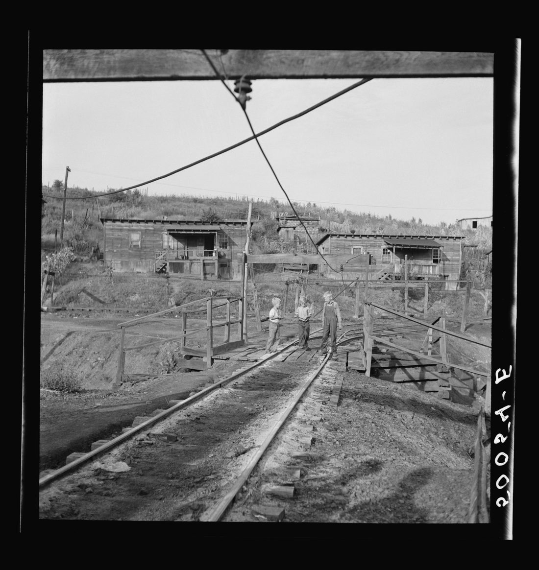 Coal miner's children on way to get groceries. All these wires are alive, carrying from 250 to 530 volts. People and children are often knocked down, sometimes killed. This is