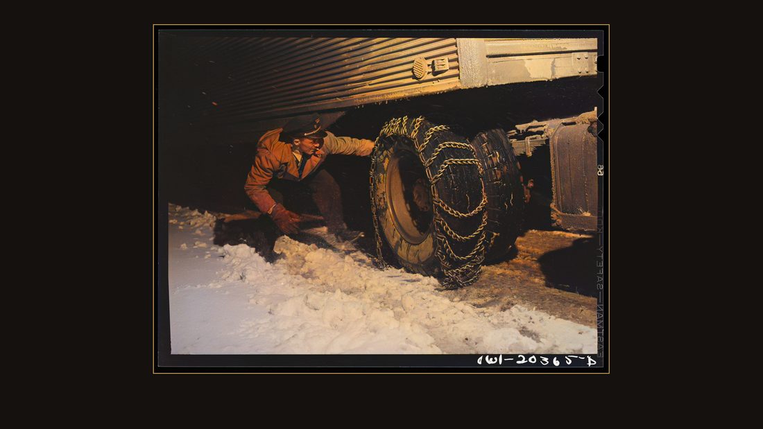 Jim Fletcher putting on chains in order to get the truck across the Blue Ridge Mountains of eastern Tennessee during a snow storm