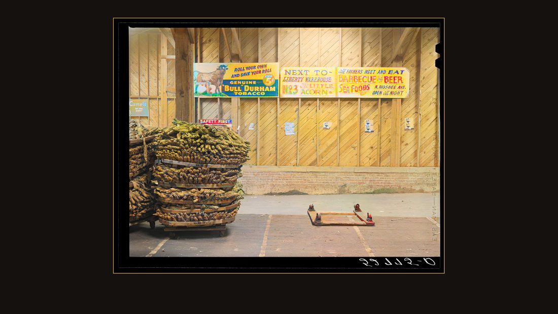 Baskets of tobacco piled on top of each other after being sold at auction. Here they are picked up by the trucks which haul them to the cigarette factories. This is in the Liberty