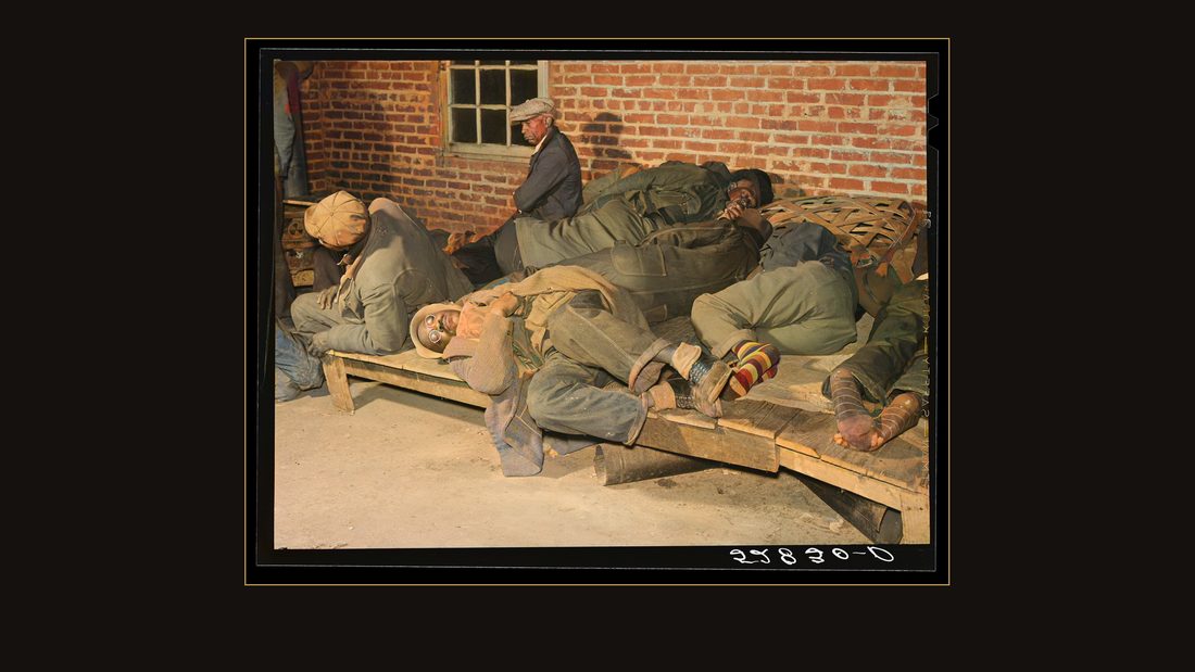Farmers sleeping in Negro camp room in warehouse. They often must remain overnight or several days before their tobacco is auctioned. Several of them are using an old tobacco baske