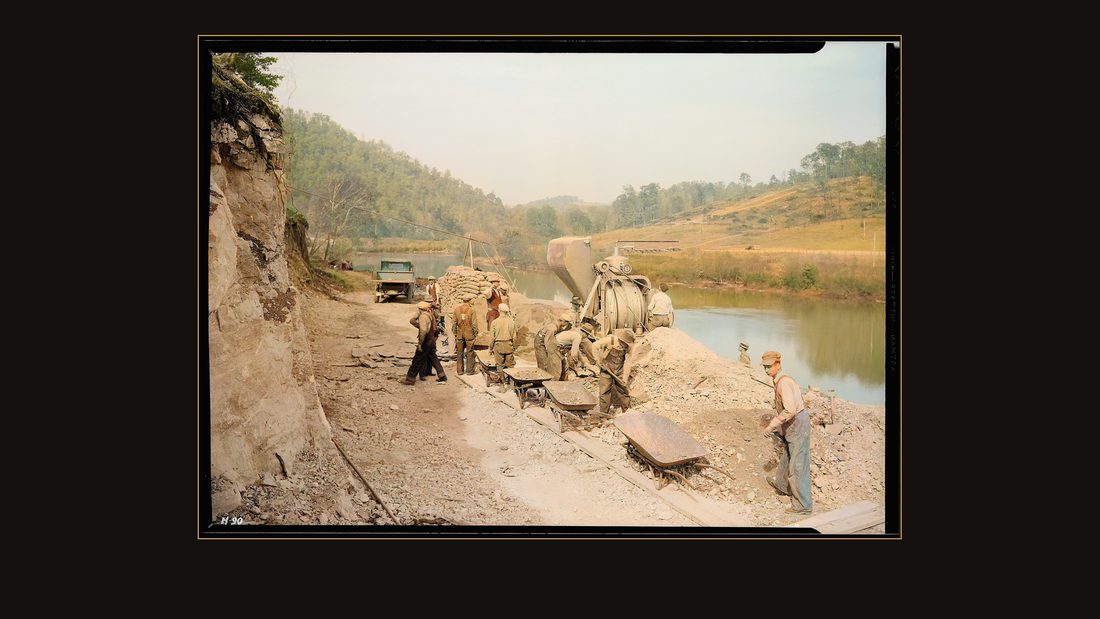 "Pouring the first batch of concrete for Crib #1 on the heavy duty construction bridge at Norris Dam site, just below the Dam itself. R. S. Carter, foreman, Hershel Womack, as