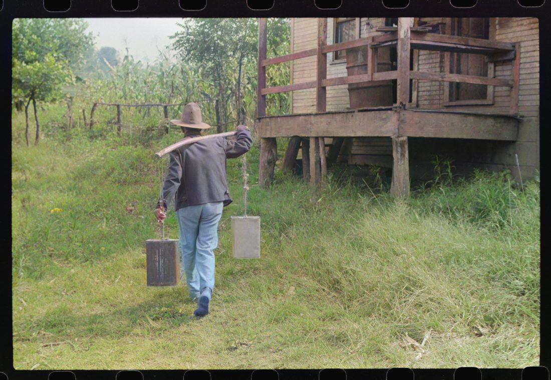 Mexican miner carrying water the way he learned as a boy, from about two miles downhill. Bertha Hill, West Virginia