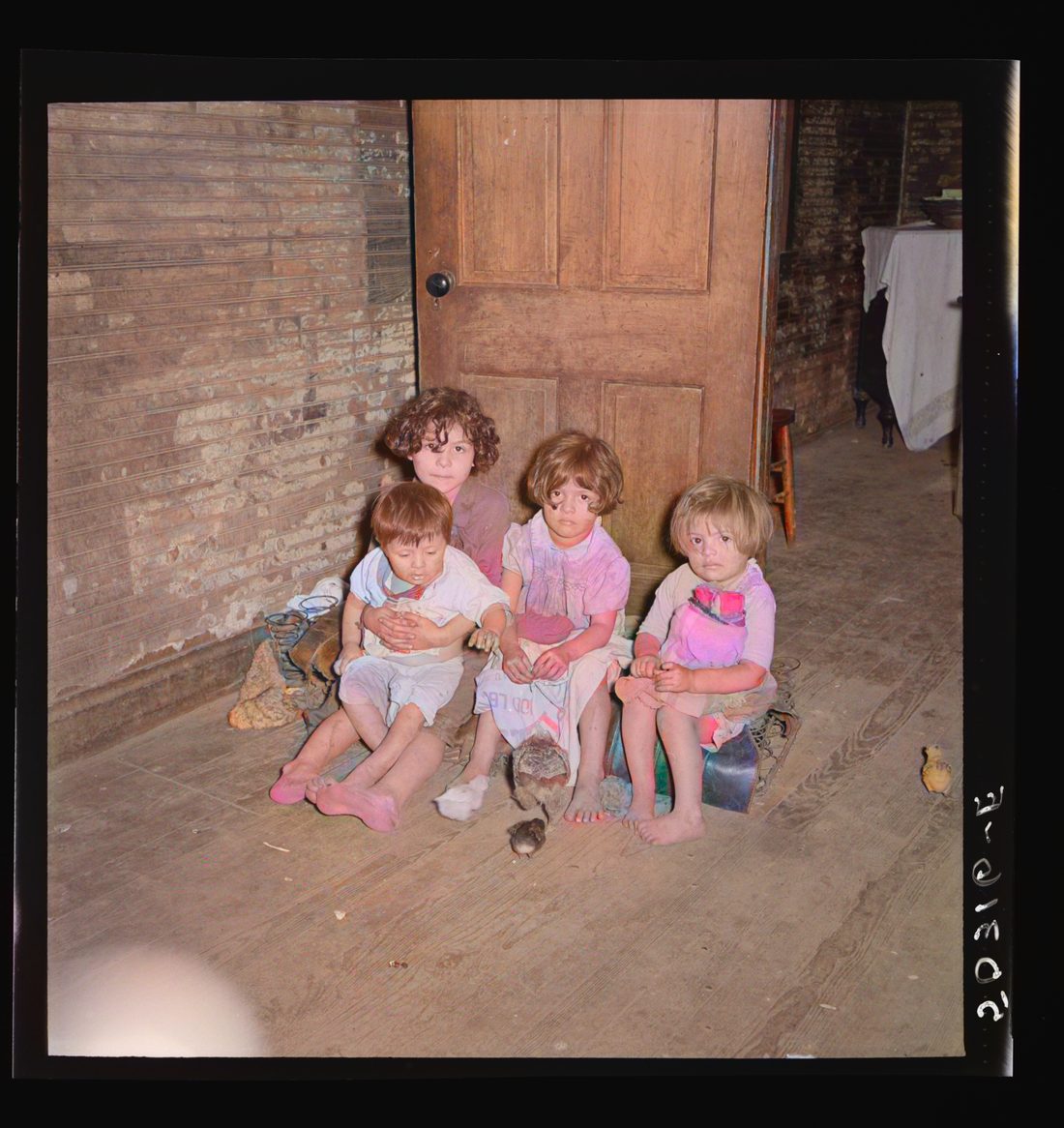 [Untitled photo, possibly related to: Mexican miner's children feeding chickens in the kitchen. Their mother is thirty years old and has had ten children. Scotts Run, Bertha H