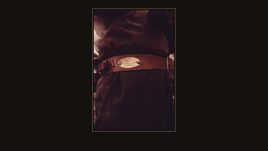 CLOSEUP OF THE BRASS WHICH IS AFFIXED TO THE BELT OF EACH MINER WHO WORKS FOR THE VIRGINIA-POCAHONTAS COAL COMPANY NEAR RICHLANDS, VIRGINIA. IT LISTS THE MINER'S SOCIAL SECURI