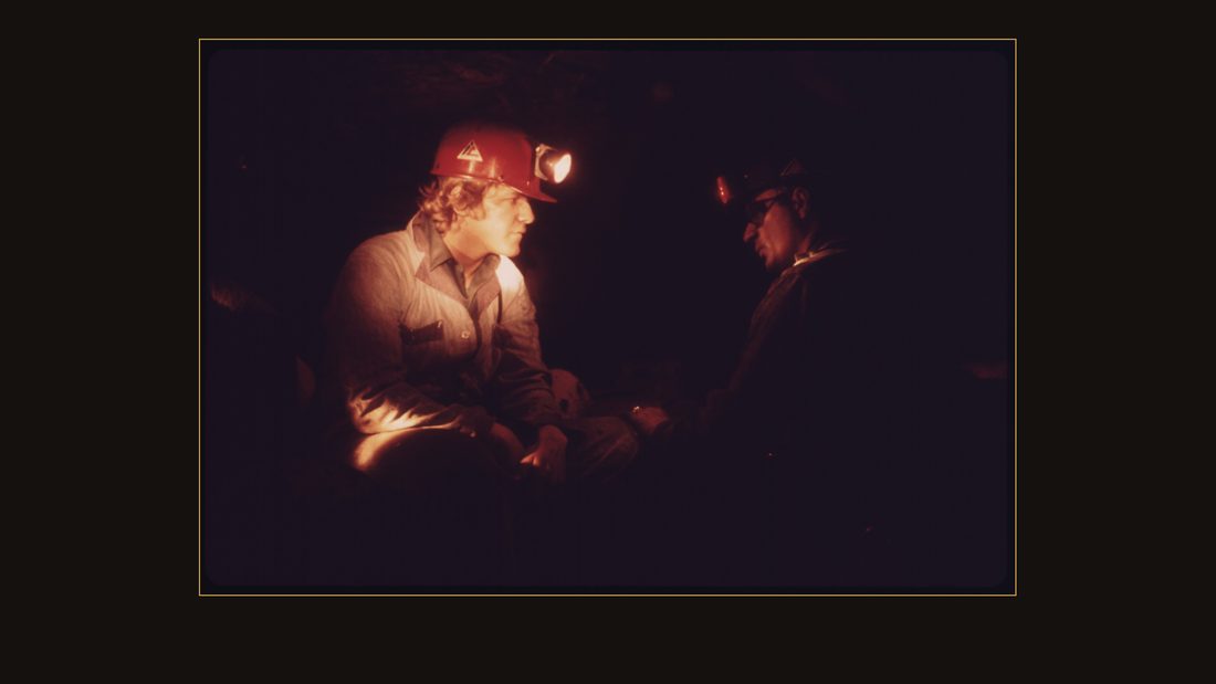 VETERAN MINER HAROLD STANLEY, RIGHT, TALKS TO A YOUNG MINER WHO HAS COME INTO THE MINE FOR THE FIRST TIME AFTER 40 HOURS OF CLASSROOM TRAINING. STANLEY PLACED HIS HAND ON THE NEW M