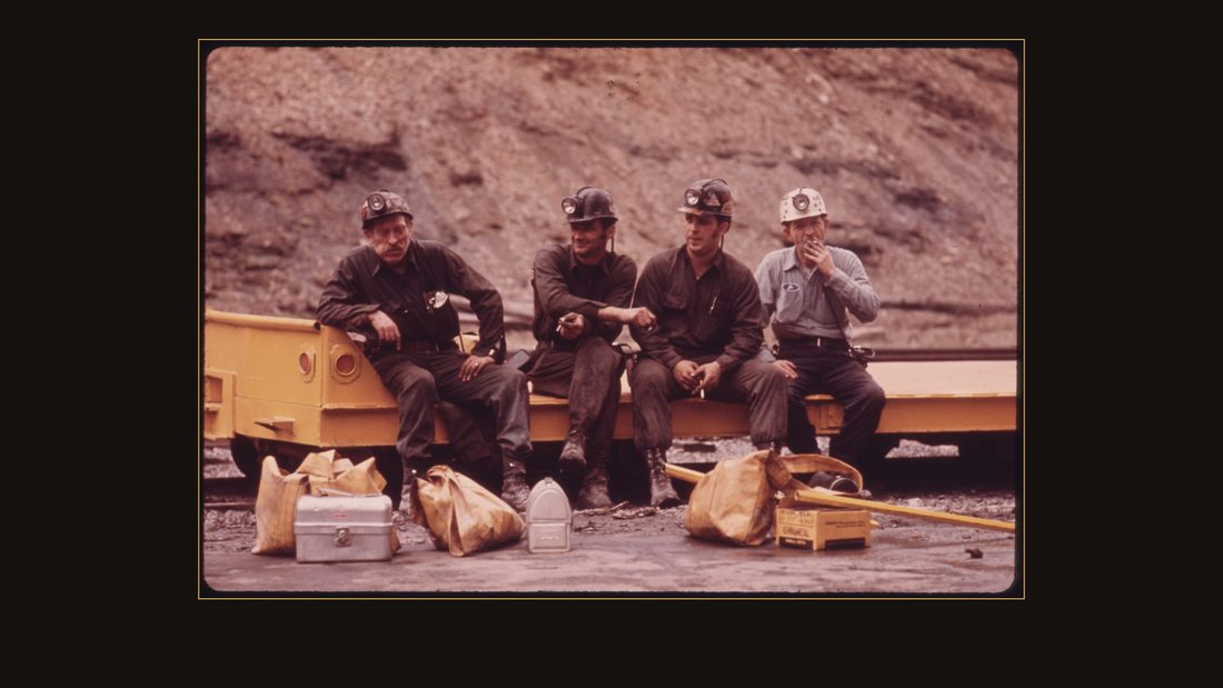 GROUP OF MINERS WAITING TO GO TO WORK ON THE 4 P.M. TO MIDNIGHT SHIFT AT THE VIRGINIA-POCAHONTAS COAL COMPANY MINE #4 NEAR RICHLANDS, VIRGINIA. THEY ARE SITTING ON A SHUTTLE CAR OF