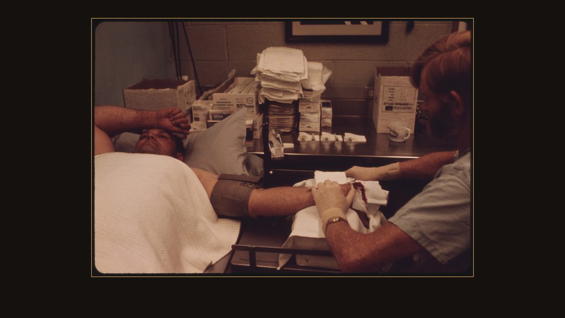DR. DONALD RASMUSSEN, PHYSICIAN AT THE BLACK LUNG LABORATORY OF THE APPALACHIAN REGIONAL HOSPITAL, IN BECKLEY, WEST VIRGINIA, PLACES A SYRINGE IN THE ARM OF A COAL MINER ABOUT TO B