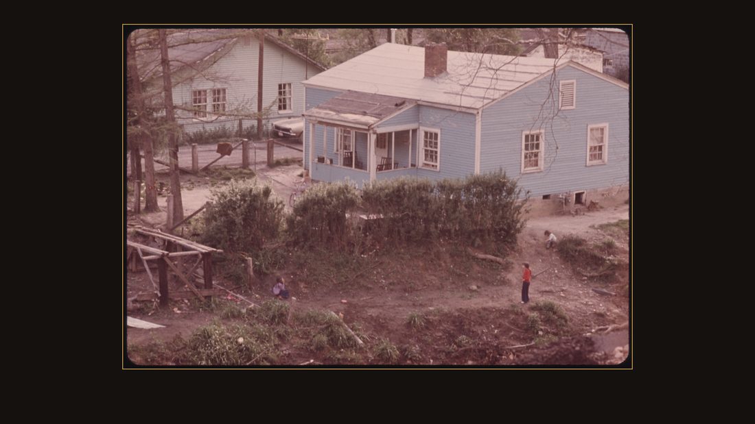KIDS PLAYING OUTSIDE A HOME IN SHARPLES, WEST VIRGINIA, NORTH OF LOGAN. NOTE THE WAY THE OWNER HAS BUILT A PLACE TO PARK HIS CAR SPACE IS AT A PREMIUM IN THE VALLEYS OF THE MINING