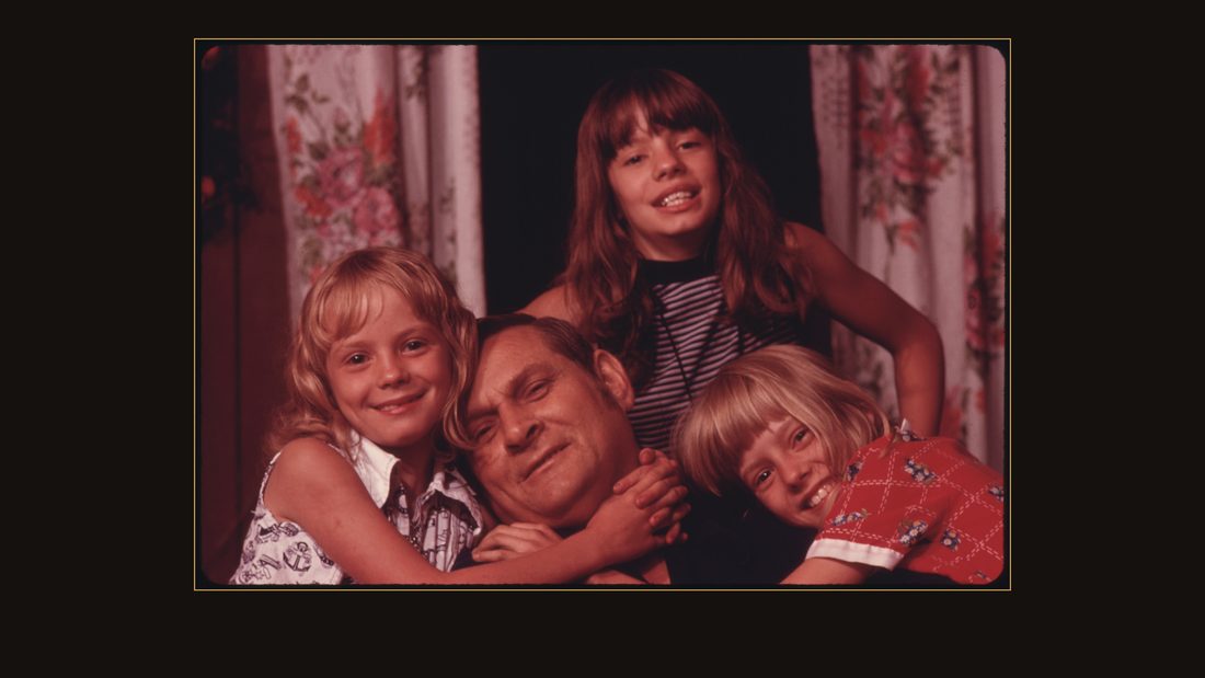 CLOSEUP OF JACK SMITH, 42, DISABLED MINER FROM RHODELL, WEST VIRGINIA, NEAR BECKLEY, WITH THREE OF HIS FOUR DAUGHTERS. HE LOST BOTH LEGS IN A MINE ACCIDENT, AND WAITED 18 YEARS BEF