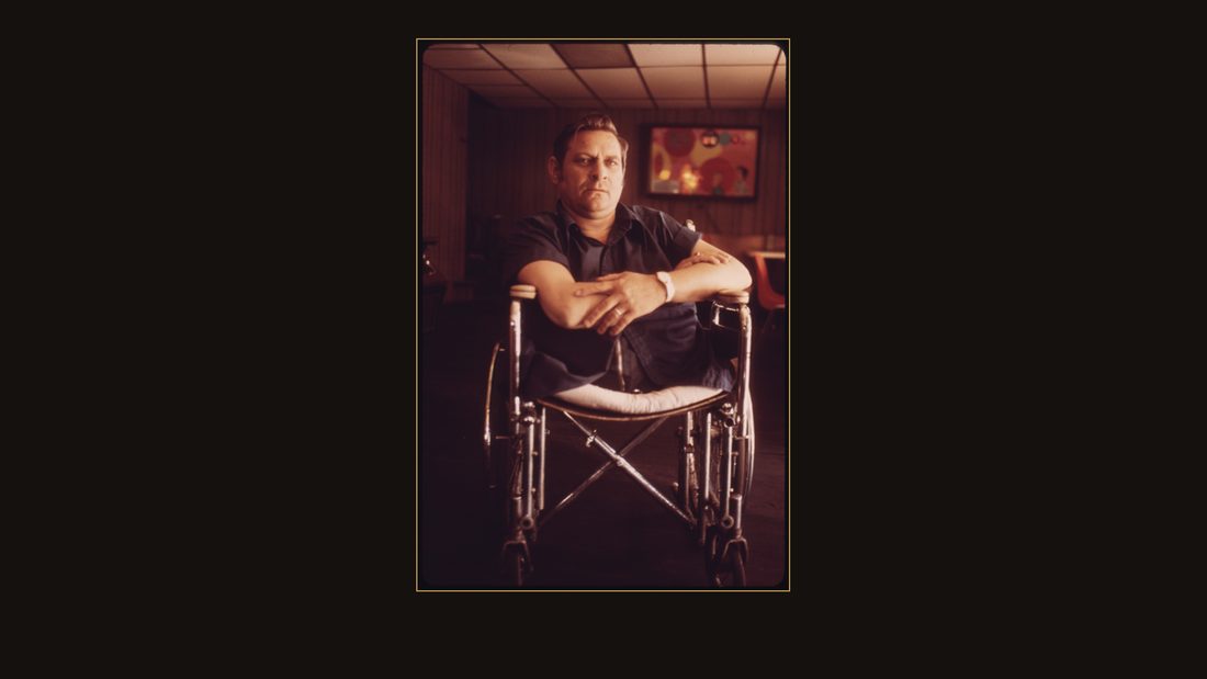 JACK SMITH, 42, RHODELL, WEST VIRGINIA, SEATED IN THE BEER JOINT HE OPERATES IN A WHEEL-CHAIR BOUGHT FOR HIM BY HIS FRIEND ARNOLD MILLER, PRESIDENT OF THE UNITED MINE WORKERS UNION